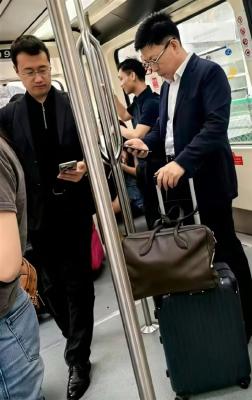 网友机场摆渡车偶遇余承东、何刚：自己拿行李箱 专注看手机-萌图百科